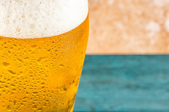 Closeup of a glass of beer with foam and water droplets 