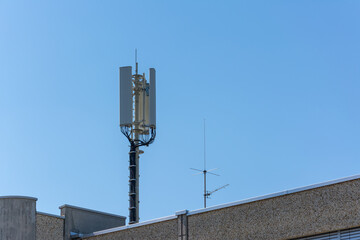 Obraz premium Cellular Antenna on Rooftop Against Blue Sky