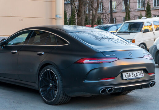 Black matte Mercedes-AMG GT 63 43 53 4MATIC parked outdoor on street background. Mercedes-Benz AMG GT 43 matte black, parked in the street. A luxury car from a famous German brand. Wrapping car PPF. 