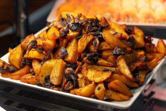Close-up of delicious roasted potato wedges with mushrooms