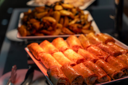 Hot buffet tray with crispy spring roll under a heat lamp