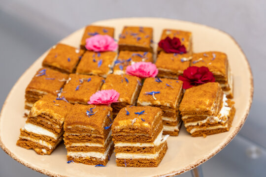 Layered honey cake squares with cream on a plate
