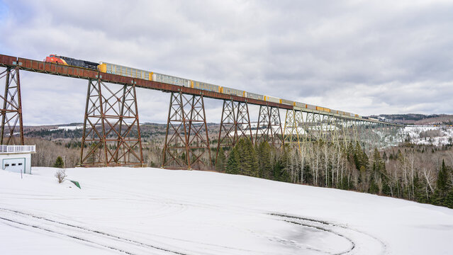 Freight train crossing long and tall trestle bridge
