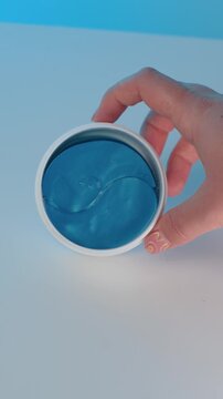 White box with under eye patches shown from left to right, clean packaging presentation, minimal skincare product concept on light background.
