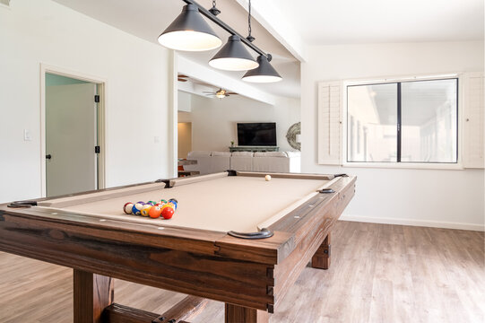 Rustic style solid wood pool table in spacious home game room lighting