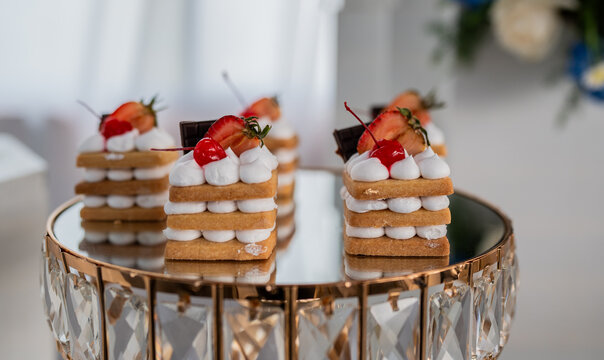 Mini postres gourmet con crema, fresa y cereza sobre base elegante para evento