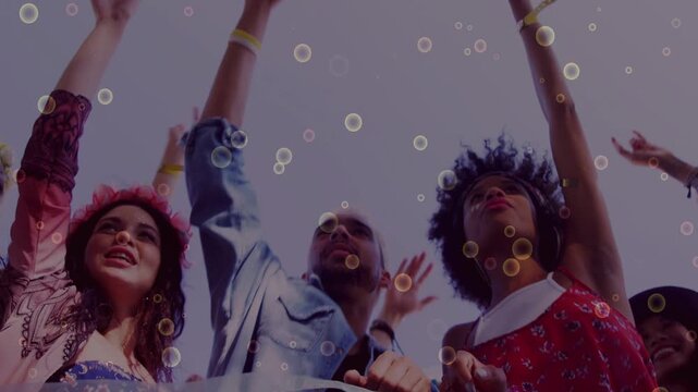 Low-angle trio raising hands after music cue, gripping barrier while bubble overlay floating
