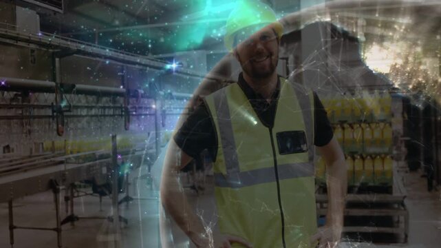 Male hard-hatted worker standing plant, CGI globe moving across frame, causing smile, showing line