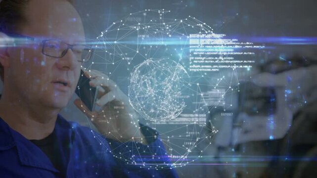 Male tech using phone at ear in garage, reading spinning digital globe while checking car status