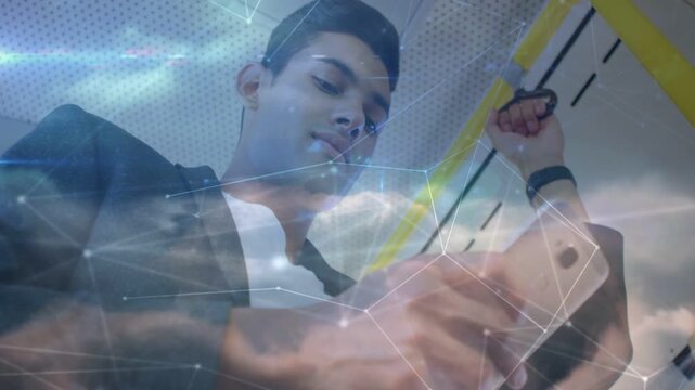 Rider on train holding rail, scrolling phone and initiating tech cloud overlay, smiling