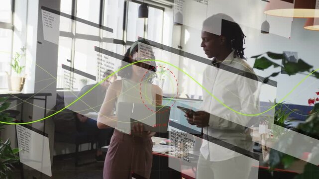 Woman toggling laptop content man tapping tablet reviewing business with overlays across screens