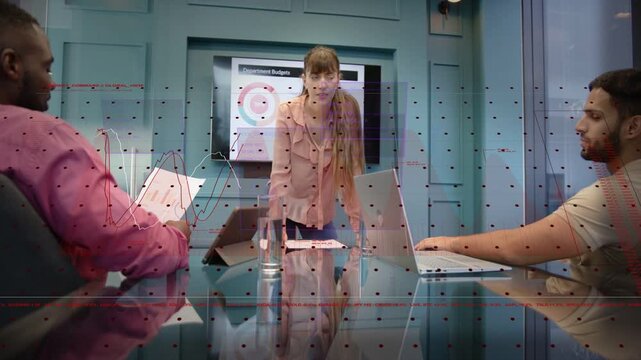 Female presenter leaning on glass table, gesturing to budget chart and initiating animated overlays