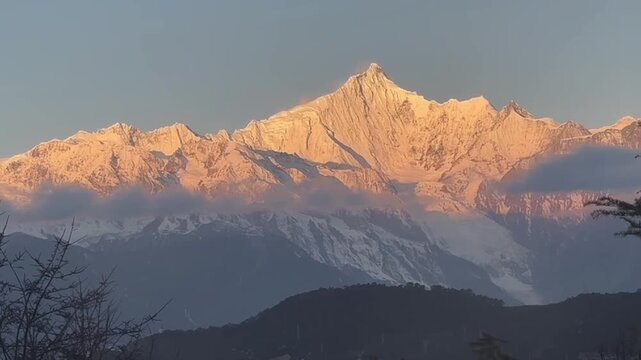Breathtaking horizontal view of the Mount Gongga range at dawn. The peak turns brilliant gold as rolling clouds pass over the high-altitude snowy wilderness in Sichuan.