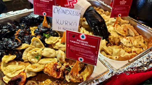 Close-up of various types of pierogi dumplings at a street food stall in the Krakow Christmas market, Poland