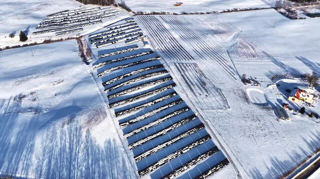 Aerial view of solar panels installed on snowy farmland in winter