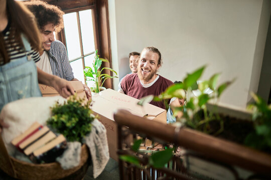Friends carrying moving boxes up apartment stairs