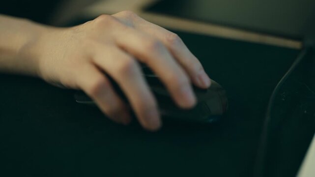 Close-up of a woman's hand operating and clicking a computer mouse