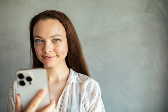 Young woman taking selfie with smartphone at home