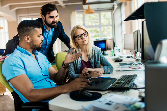 Coworkers collaborating on project at modern office