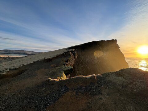 Cliff Edge at Sunset Over Ocean with Golden Light