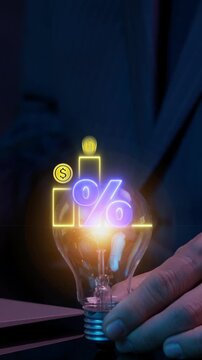 Profit high growth percent icon, stocks, financial, Interest rate and dividend concept. Businessman showing glowing lightbulb and animation of dollar sign graph and chart with percentage icon.