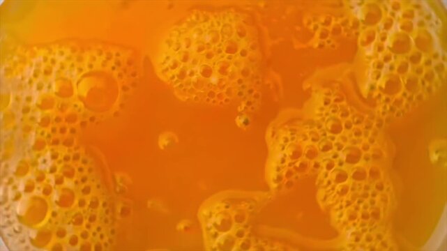orange juice macro with bubbles, fresh citrus liquid texture close-up, vibrant natural drink with foam and pulp, refreshing vitamin beverage background and healthy nutrition concept