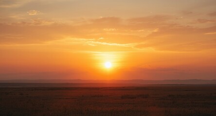 Fototapeta premium Sunset splashing warm golden colors across a large open area with light cloud patterns in summer