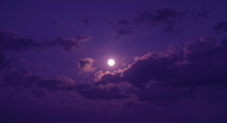 Fototapeta premium Vivid purple night sky backdrop displaying silhouetted clouds and a bright full moon