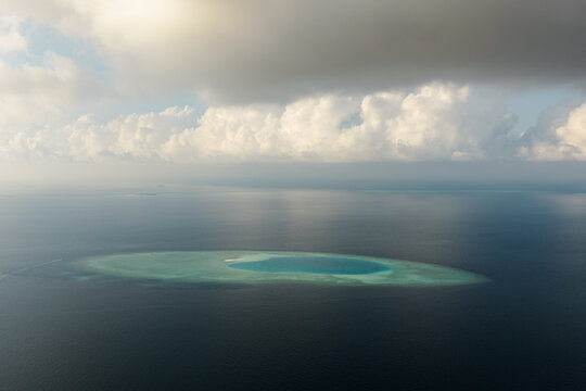 Aerial view of ring shaped atoll in the Indian Ocean at sunset, Maldives