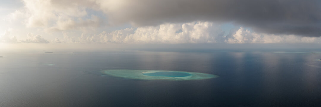 Aerial panoramic view of ring shaped atoll in the Indian Ocean at sunset, Maldives