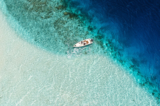 Aerial view of motorboat in the blue sea of Maldives