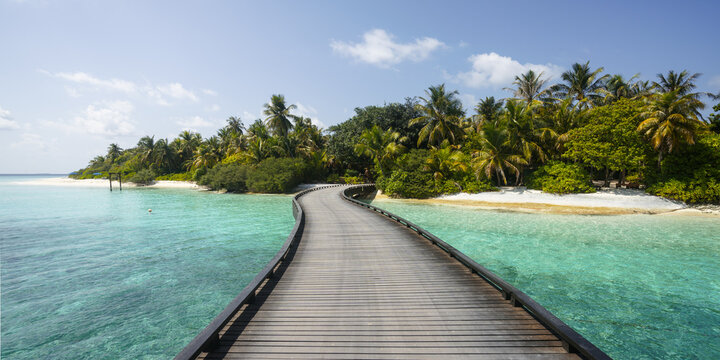 Panoramic shot of wooden jetty leading to an island in the Maldives