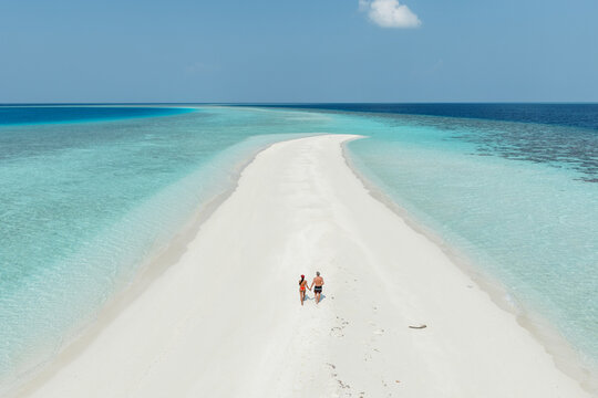 Aerial view of romantic couple on a sandbar in the indian ocean, Maldives
