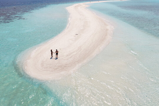 Aerial view of romantic couple on a sandbar in the indian ocean, Maldives