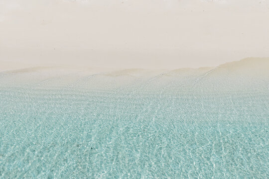 Aerial top down view of white sand beach and ocean in the Maldives