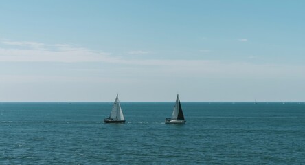 Fototapeta premium Two sailboats navigating tranquil ocean waters under clear sky