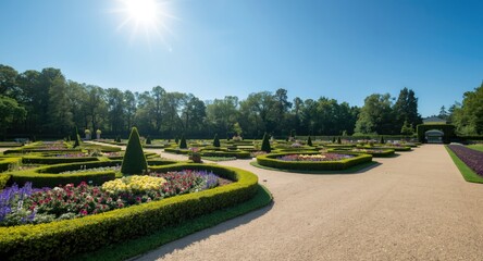 Fototapeta premium Sunlit public garden showcasing manicured hedge shapes and brilliant flower displays beside neat pathways under blue sky