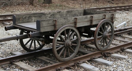 Fototapeta premium Traditional wooden cart with old metal wheels by train tracks