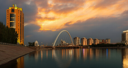Naklejka premium The dramatic sky over the Ishim River in the center of Kazakhstan's capital, Astana.
