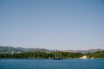 Fototapeta premium Tranquil waters with anchored boats. Peaceful ocean view featuring boats and mountains
