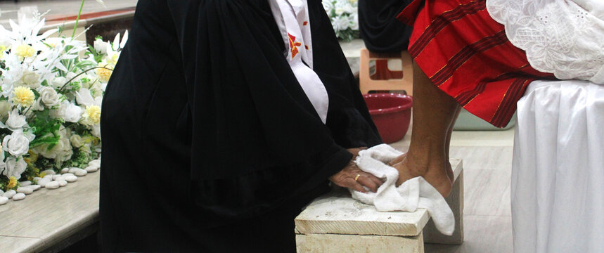 Religious Footwashing Ceremony, Maundy Thursday, a priest gently washes the feet of the congregation.