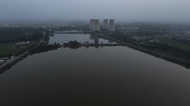 Aerial View of Bathinda Thermal Power Plant Cooling Towers and Lake in Hazy Twilight.