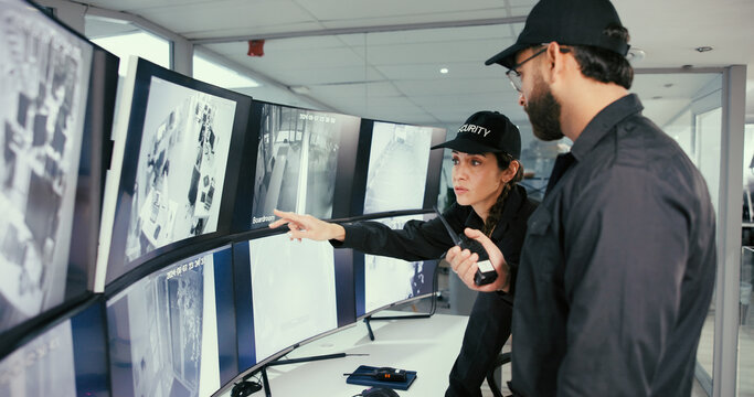 Security, control room and team with radio by monitor for communication, surveillance or report. Safety officer, computer screen and people point or talk about breach, property inspection or dispatch