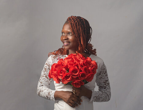Beautiful Nigerian Woman in Lace Top Holding Roses Studio Portrait