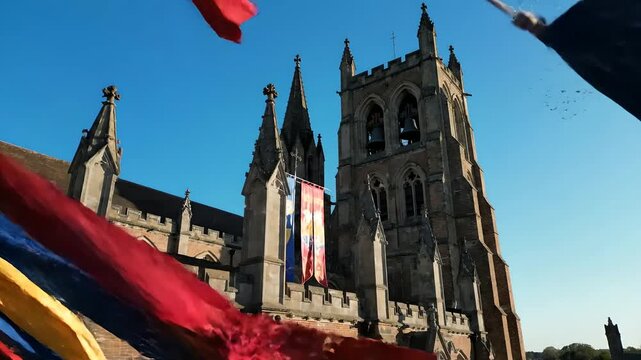 Catedral decorada con banderas festivas bajo cielo azul, p&aacute;jaros volando de la torre, celebraci&oacute;n de Cinco de Mayo, arquitectura hist&oacute;rica y cultura religiosa vibrante.