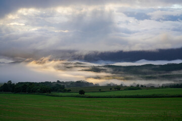 Morning fog over green farmland with mountains in summer Hokkaido Japan, captured in the pristine wilderness of northern Hokkaido, Japan © foto