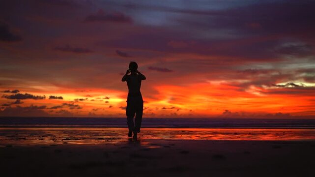 Woman Silhouette at Dramatic Red Sunset on Pantai Kelating Beach Bali