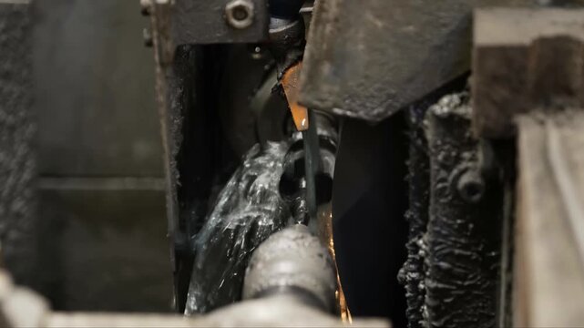 Industrial CNC machine sharpens a steel auger bit with coolant