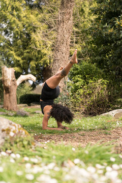 Woman practicing yoga forearm stand in nature