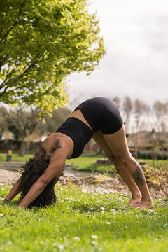 Woman practicing downward-facing dog yoga pose outdoors